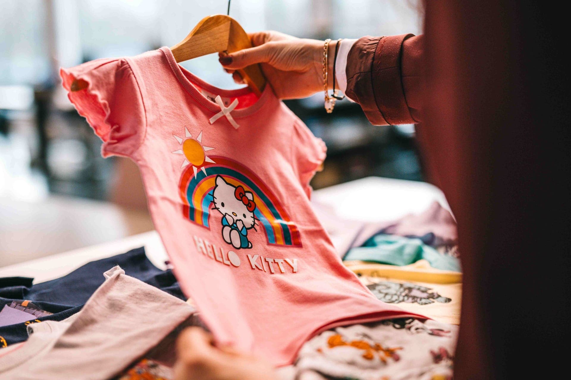 Roze Hello Kitty-t-shirt met regenboogprint aan een kleerhanger