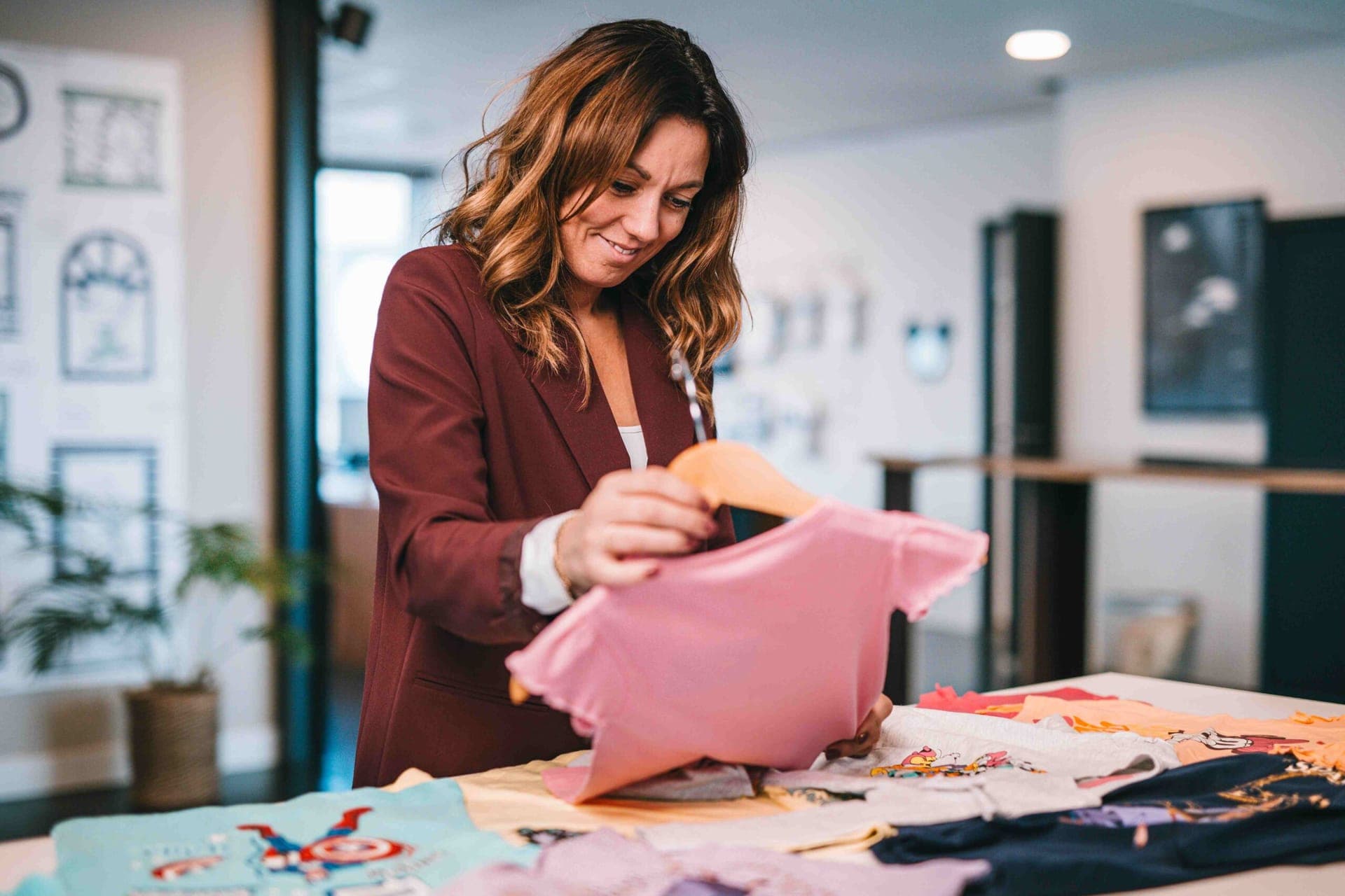 Collega kiest een roze t-shirt uit een tafel vol gelicentieerde kinder-t-shirts